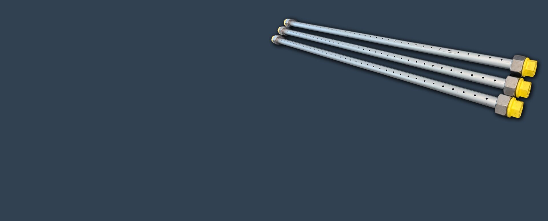 Mehrere glänzende Metallrohre mit präzisen Biegungen liegen gestapelt übereinander. An den Enden sind gelbe Schutzkappen aufgeschraubt. Die Rohre wirken robust und gleichmäßig verarbeitet. Der Hintergrund ist schwarz.